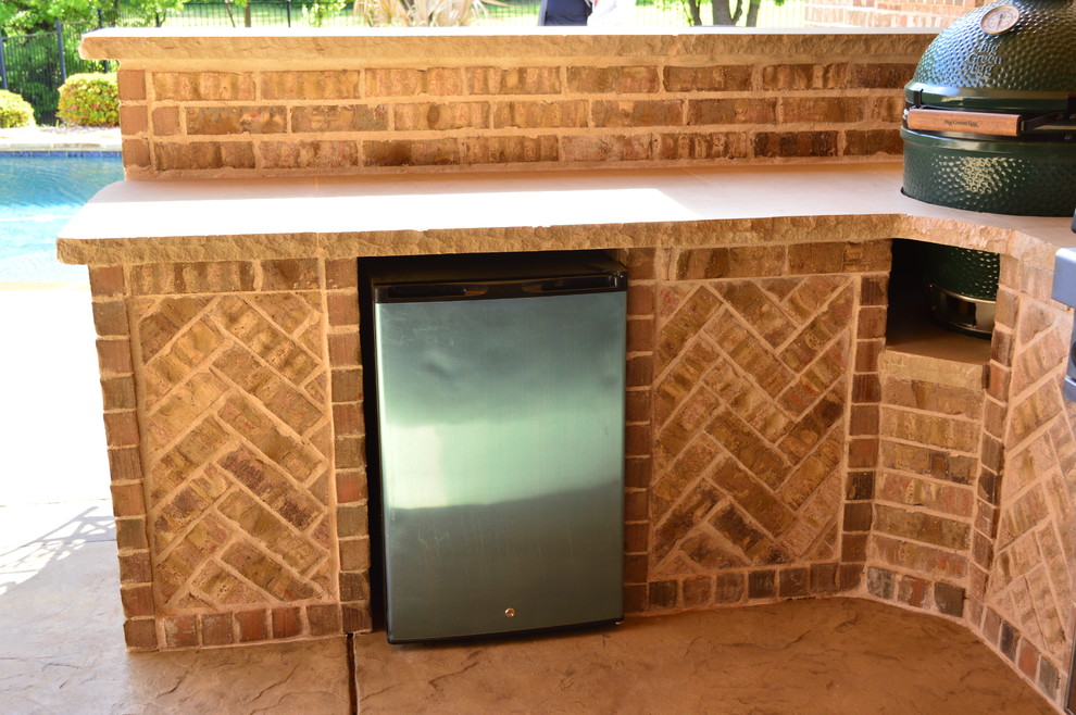 Photo of a mid-sized country backyard patio in Dallas with an outdoor kitchen and stamped concrete.