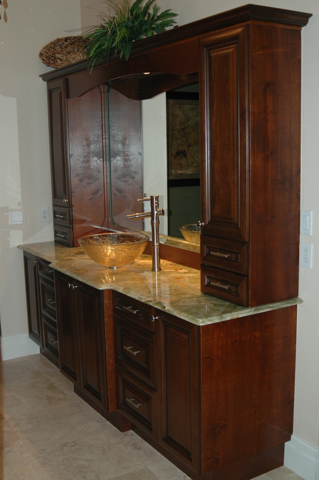 Inspiration for a mid-sized traditional master bathroom in Other with raised-panel cabinets, dark wood cabinets, black walls, travertine floors, a vessel sink, onyx benchtops, beige floor and green benchtops.