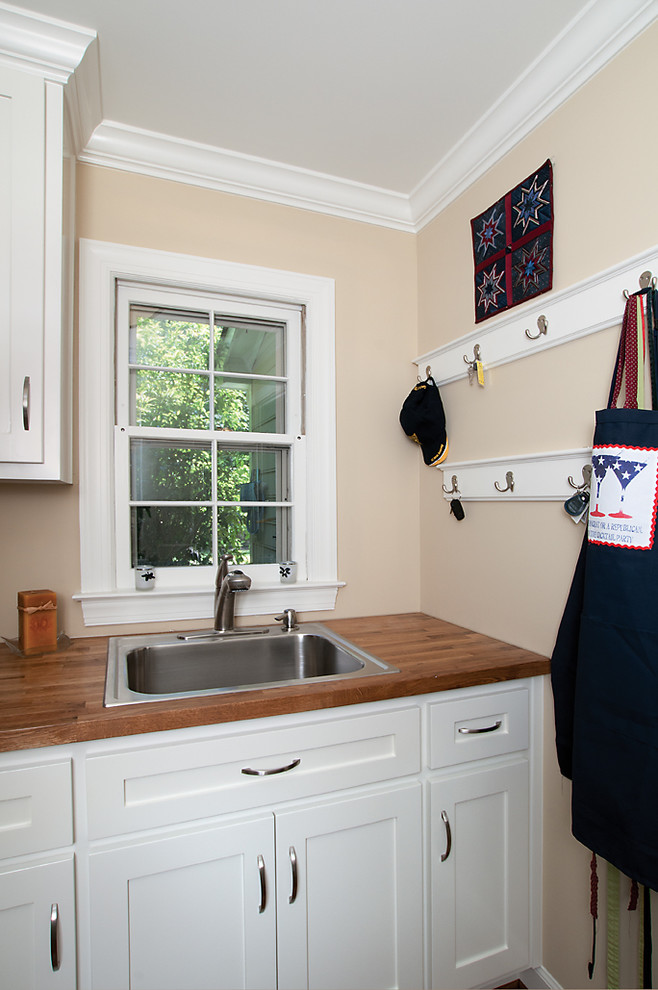 Inspiration for a traditional laundry room in Atlanta with a drop-in sink, white cabinets and wood benchtops.
