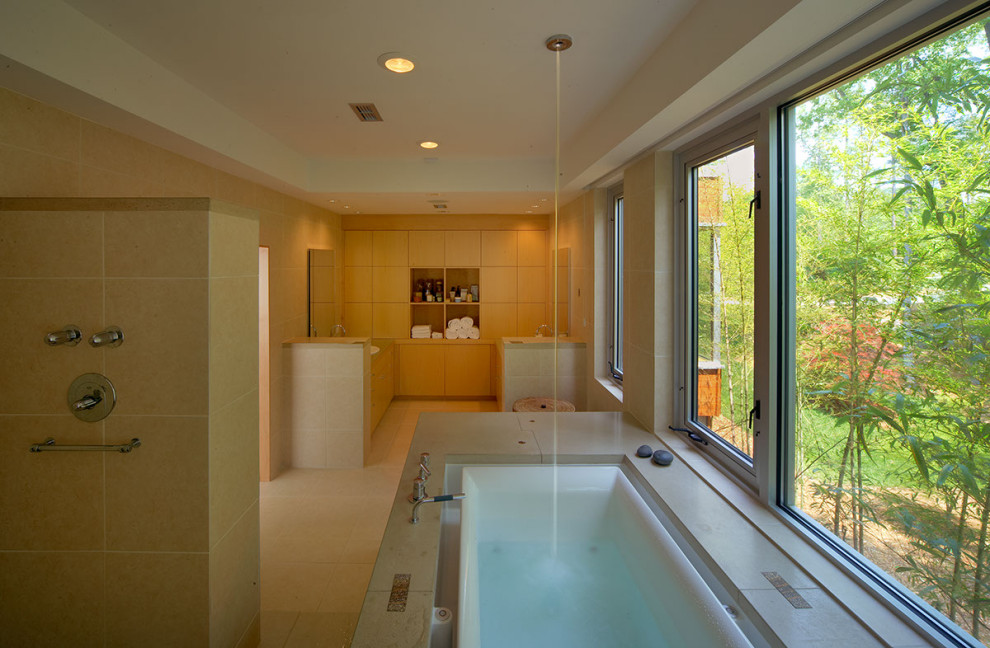 This is an example of a large contemporary master bathroom in Other with furniture-like cabinets, light wood cabinets, an undermount tub, an open shower, a wall-mount toilet, beige tile, travertine, beige walls, travertine floors, a drop-in sink, concrete benchtops, beige floor, an open shower, beige benchtops, an enclosed toilet, a double vanity and a built-in vanity.