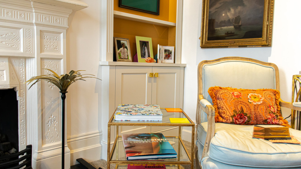 Photo of a medium sized classic living room in Dorset with orange walls, carpet, a standard fireplace, a stone fireplace surround, a wall mounted tv, beige floors and a chimney breast.