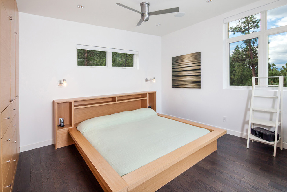 Design ideas for a modern bedroom in Vancouver with white walls and dark hardwood floors.