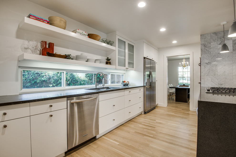 Photo of a large scandinavian galley separate kitchen in Dallas with a double-bowl sink, open cabinets, white cabinets, stainless steel appliances, light hardwood floors, with island, quartz benchtops, grey splashback and stone tile splashback.