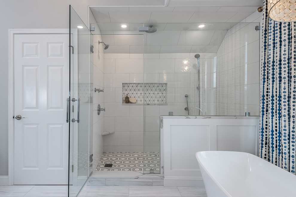 Large modern master bathroom in Boston with recessed-panel cabinets, blue cabinets, a freestanding tub, a curbless shower, a one-piece toilet, gray tile, ceramic tile, grey walls, ceramic floors, an undermount sink, engineered quartz benchtops, grey floor, a hinged shower door, white benchtops, a shower seat, a double vanity and a built-in vanity.