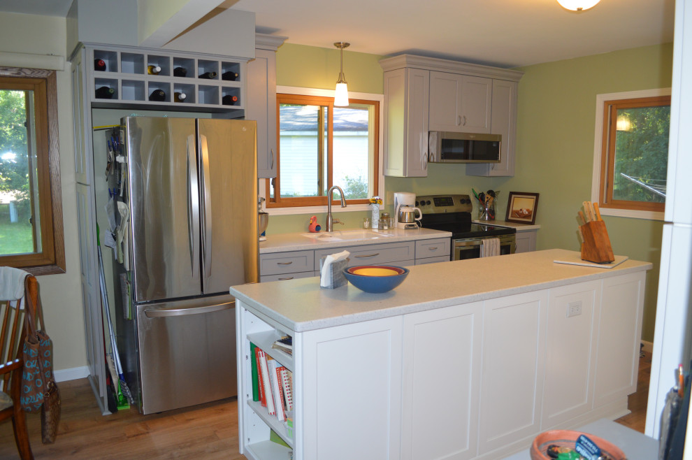 Eat-in kitchen - small transitional single-wall vinyl floor eat-in kitchen idea with an undermount sink, shaker cabinets, gray cabinets, solid surface countertops, stainless steel appliances, an island and white countertops