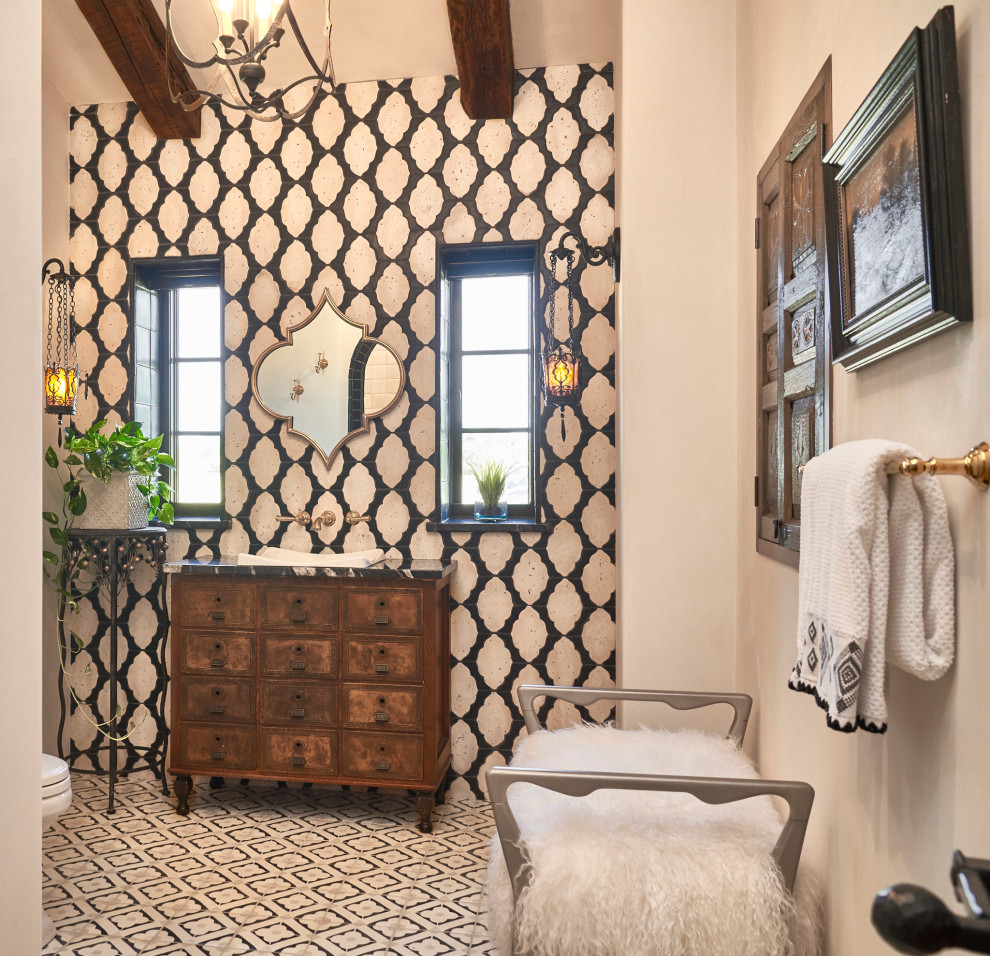 Photo of a powder room in Wichita with flat-panel cabinets, medium wood cabinets, black and white tile, beige walls, a drop-in sink, multi-coloured floor, black benchtops, a freestanding vanity and exposed beam.