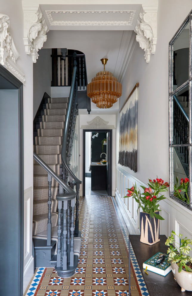 This is an example of a traditional entry hall in London with grey walls, multi-coloured floor and decorative wall panelling.