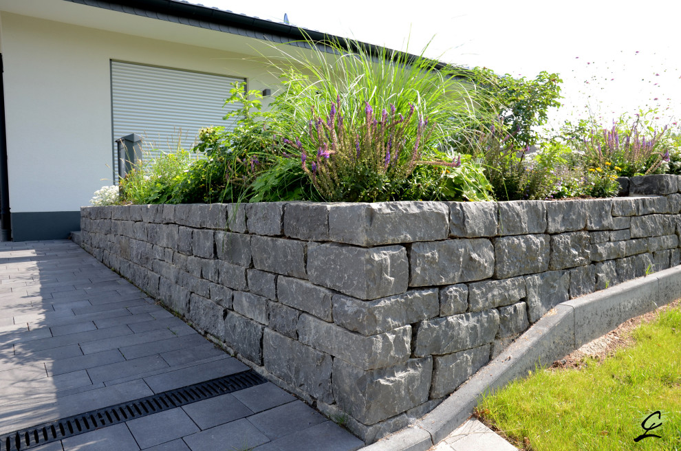 Large contemporary side yard full sun driveway in Frankfurt with natural stone pavers for summer.