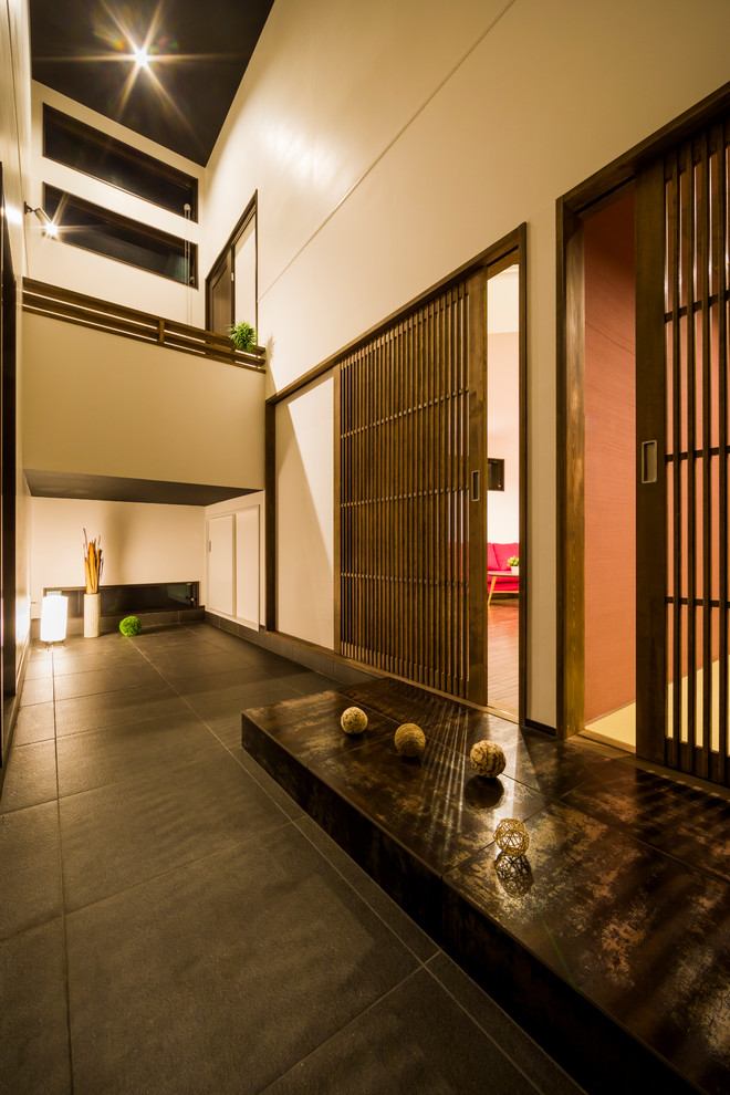 Asian entryway in Other with white walls, porcelain floors and black floor.