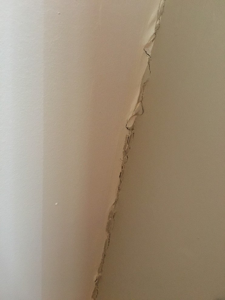 Cracks where ceiling meets wall stairwell