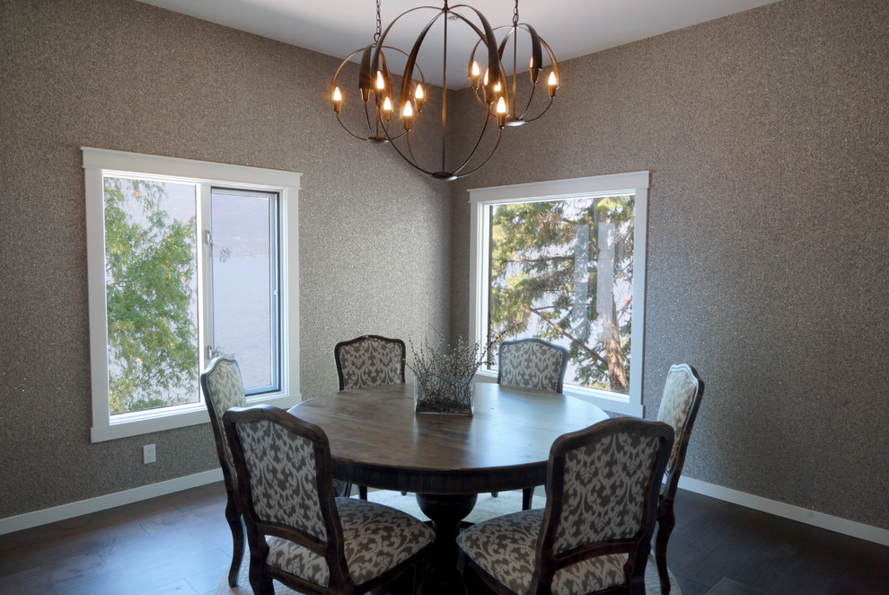 This is an example of a mid-sized traditional separate dining room in Other with grey walls, dark hardwood floors, a two-sided fireplace, a stone fireplace surround and brown floor.
