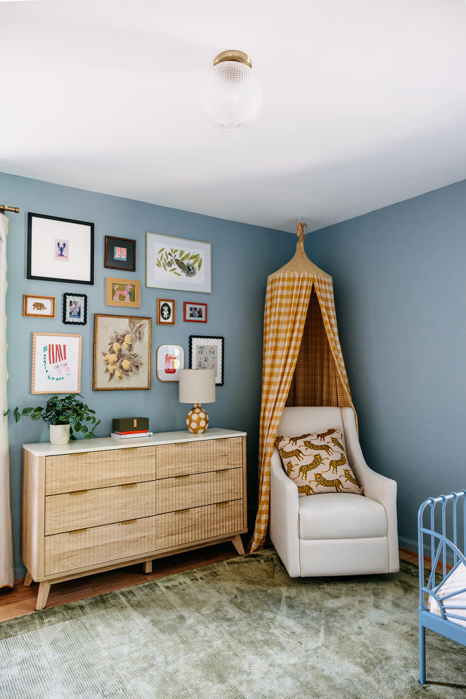 Inspiration for an eclectic medium tone wood floor and brown floor nursery remodel in Detroit with blue walls