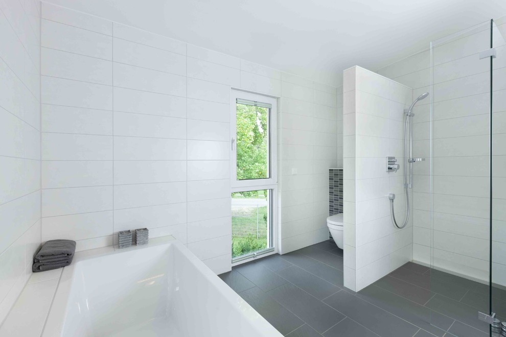 Design ideas for a large contemporary 3/4 bathroom in Stuttgart with a drop-in tub, a curbless shower, a two-piece toilet, white tile, ceramic tile, grey walls, ceramic floors, black floor and an open shower.