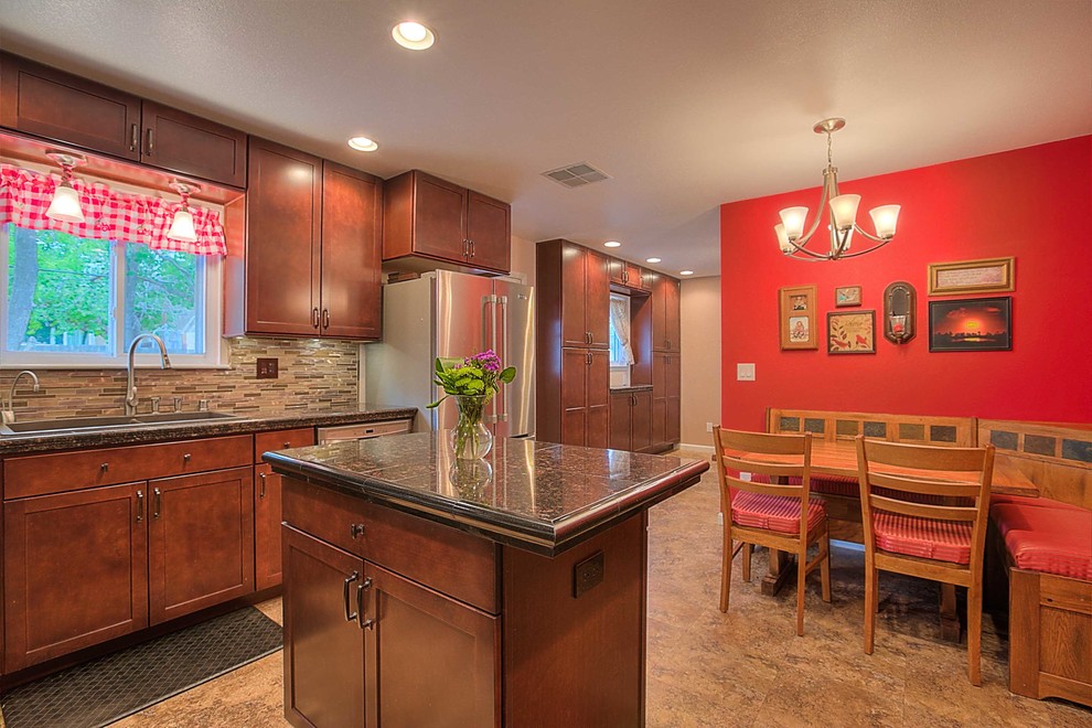 Mid-sized transitional l-shaped medium tone wood floor enclosed kitchen photo in Albuquerque with a drop-in sink, shaker cabinets, granite countertops, multicolored backsplash, glass tile backsplash, stainless steel appliances and an island