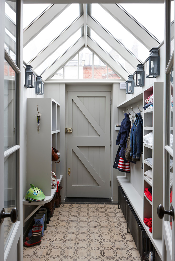 Photo of a transitional mudroom in London with a single front door and a gray front door.