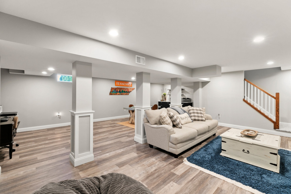 Example of a mid-sized minimalist underground medium tone wood floor and brown floor basement design in Philadelphia with a bar and white walls