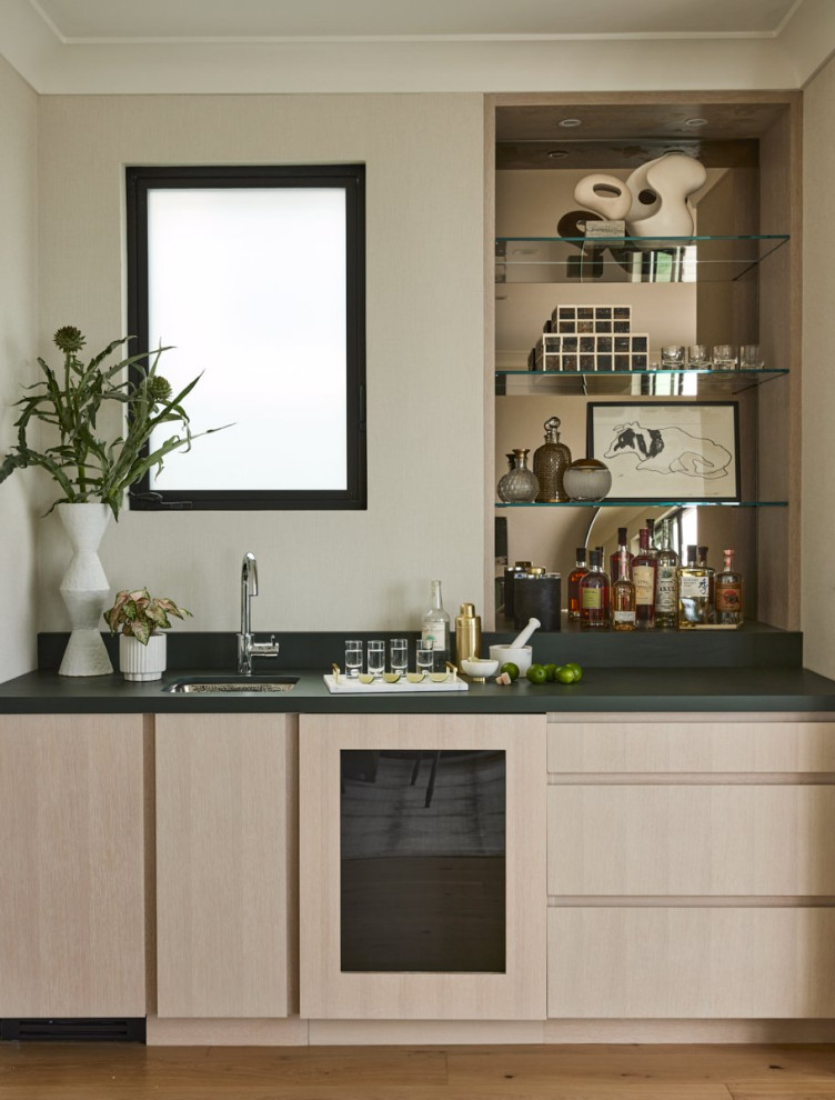 Modelo de bar en casa lineal contemporáneo de tamaño medio con fregadero bajoencimera, armarios con paneles lisos, encimera de granito y suelo de madera en tonos medios