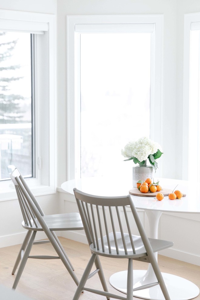 Inspiration for a large transitional u-shaped medium tone wood floor and brown floor eat-in kitchen remodel in Calgary with an undermount sink, shaker cabinets, white cabinets, quartzite countertops, white backsplash, subway tile backsplash, stainless steel appliances, an island and white countertops