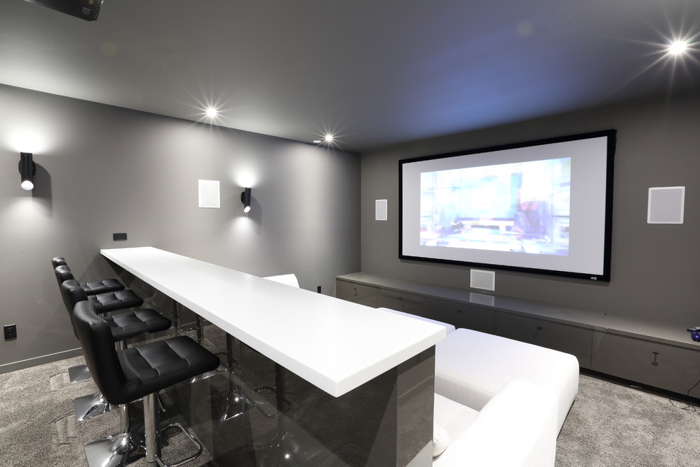 Photo of a mid-sized contemporary enclosed home theatre in Vancouver with grey walls, carpet, a projector screen and grey floor.