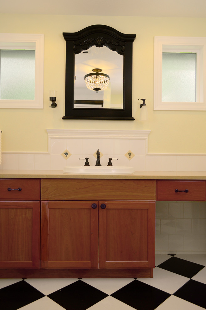 Inspiration for a mid-sized traditional master bathroom in Seattle with shaker cabinets, medium wood cabinets, an alcove shower, white tile, ceramic tile, yellow walls, vinyl floors, a drop-in sink and engineered quartz benchtops.