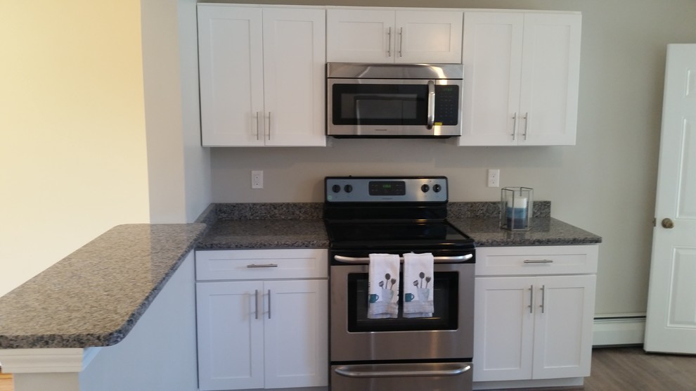 Eat-in kitchen - mid-sized transitional l-shaped eat-in kitchen idea with a single-bowl sink, shaker cabinets, white cabinets, granite countertops, stainless steel appliances and a peninsula