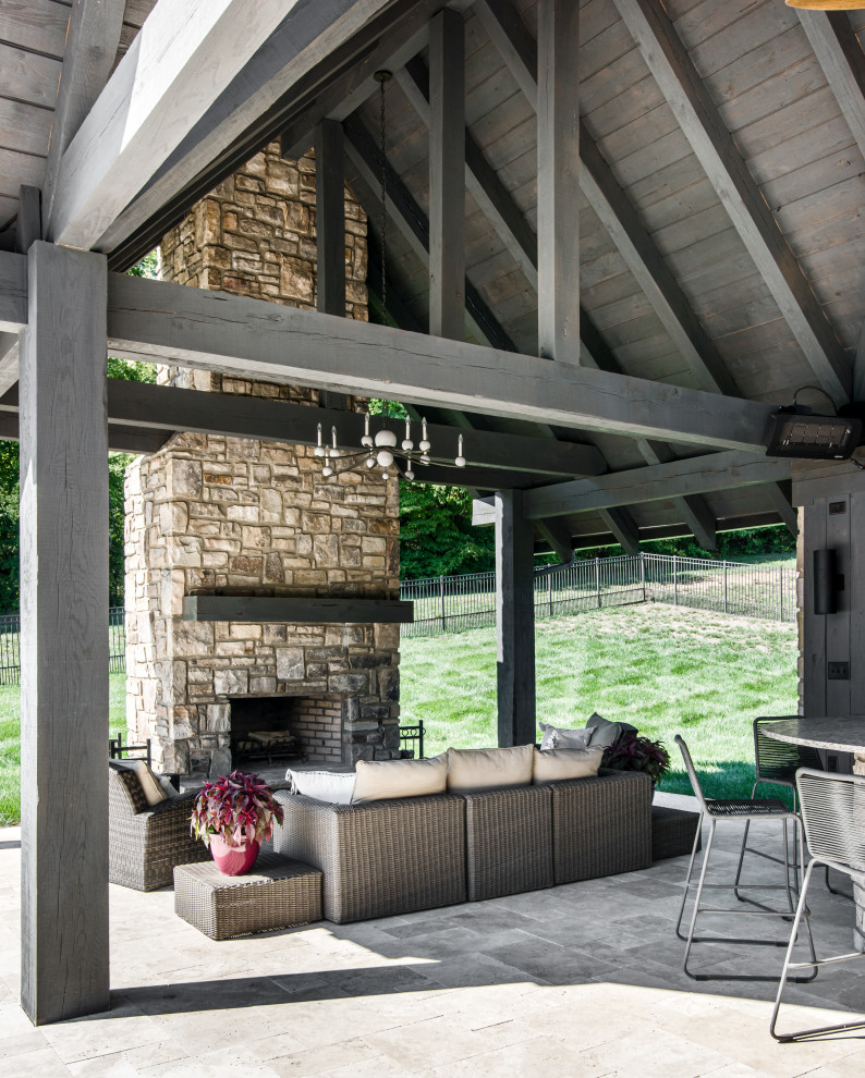 Expansive classic back veranda in Nashville with a fireplace, natural stone paving and a roof extension.
