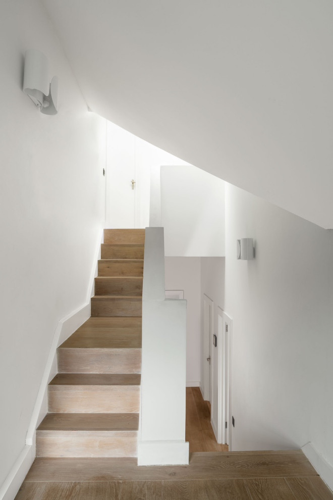 Стильный дизайн: большой коридор: освещение в современном стиле с белыми стенами, светлым паркетным полом, бежевым полом и многоуровневым потолком - последний тренд