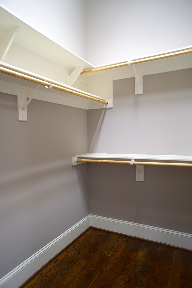 This is an example of a large contemporary gender-neutral walk-in wardrobe in Raleigh with open cabinets, white cabinets and medium hardwood floors.