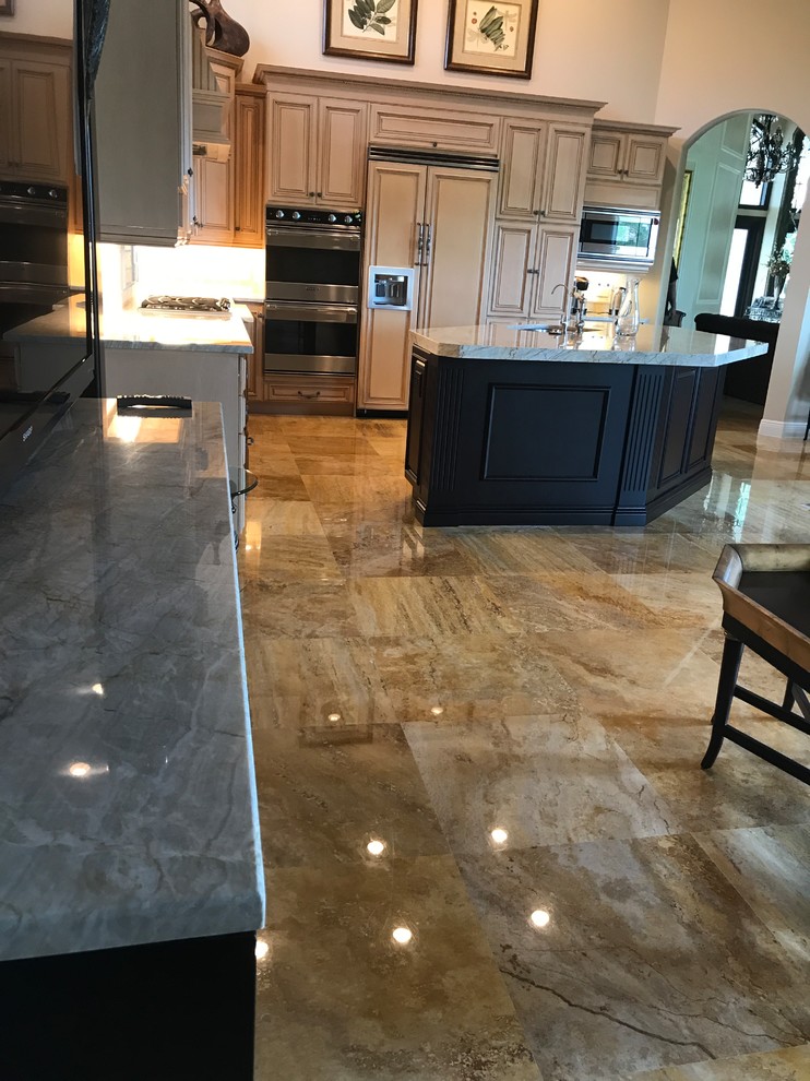 Inspiration for a mid-sized transitional l-shaped brown floor kitchen remodel in Miami with an undermount sink, raised-panel cabinets, light wood cabinets, paneled appliances and an island
