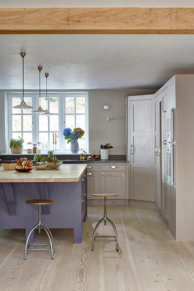 Design ideas for a country kitchen in London with beige cabinets and with island.