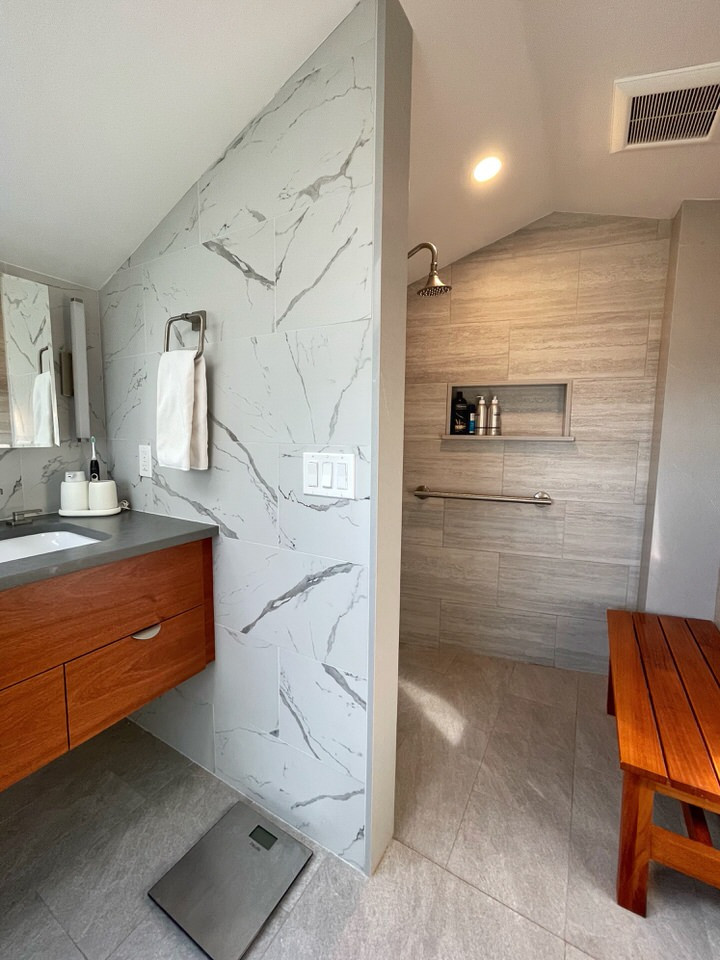 Large modern master bathroom in Providence with flat-panel cabinets, medium wood cabinets, an open shower, white tile, porcelain tile, grey walls, porcelain floors, an undermount sink, engineered quartz benchtops, grey floor, an open shower, grey benchtops, a double vanity and a floating vanity.