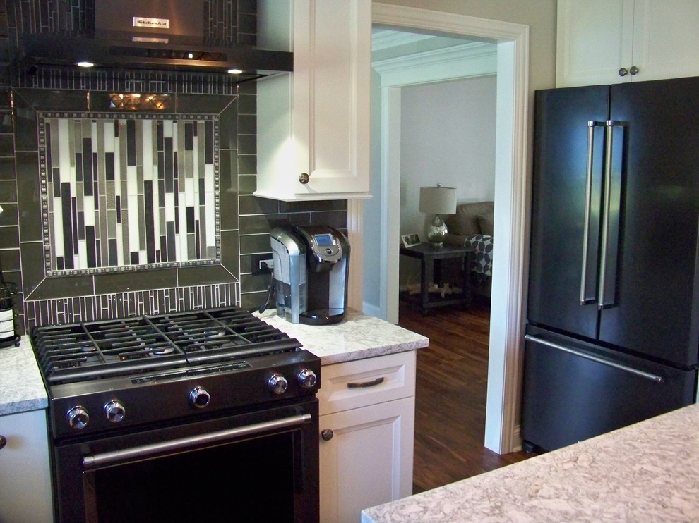 Inspiration for a mid-sized transitional l-shaped medium tone wood floor and brown floor open concept kitchen remodel in Chicago with a farmhouse sink, recessed-panel cabinets, white cabinets, granite countertops, brown backsplash, subway tile backsplash, stainless steel appliances and an island