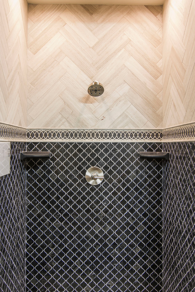Photo of a mediterranean bathroom in Minneapolis with a curbless shower, beige tile, stone tile and black walls.
