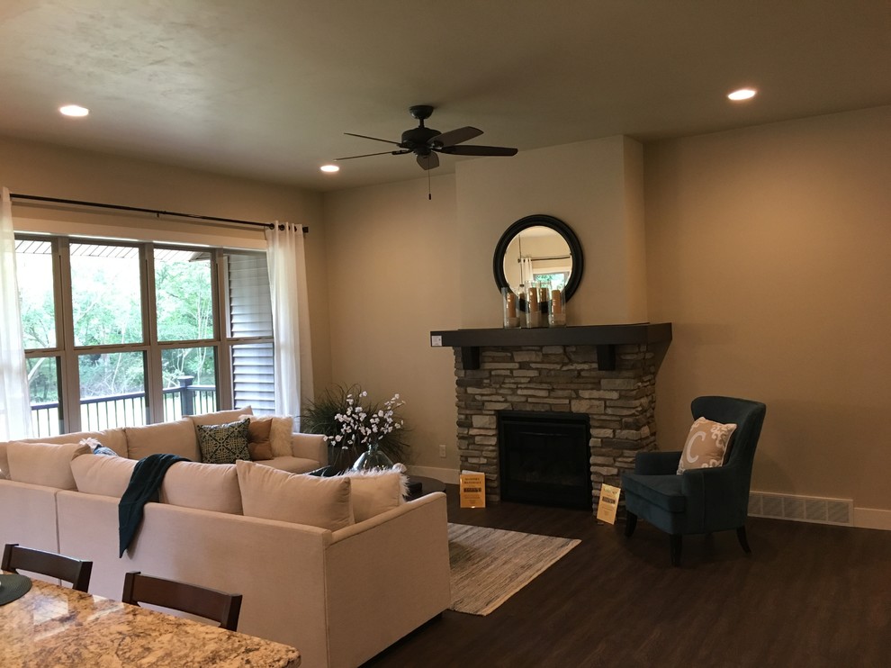 Mid-sized modern open concept living room in Other with a home bar, beige walls, vinyl floors, a standard fireplace, a stone fireplace surround, no tv and brown floor.