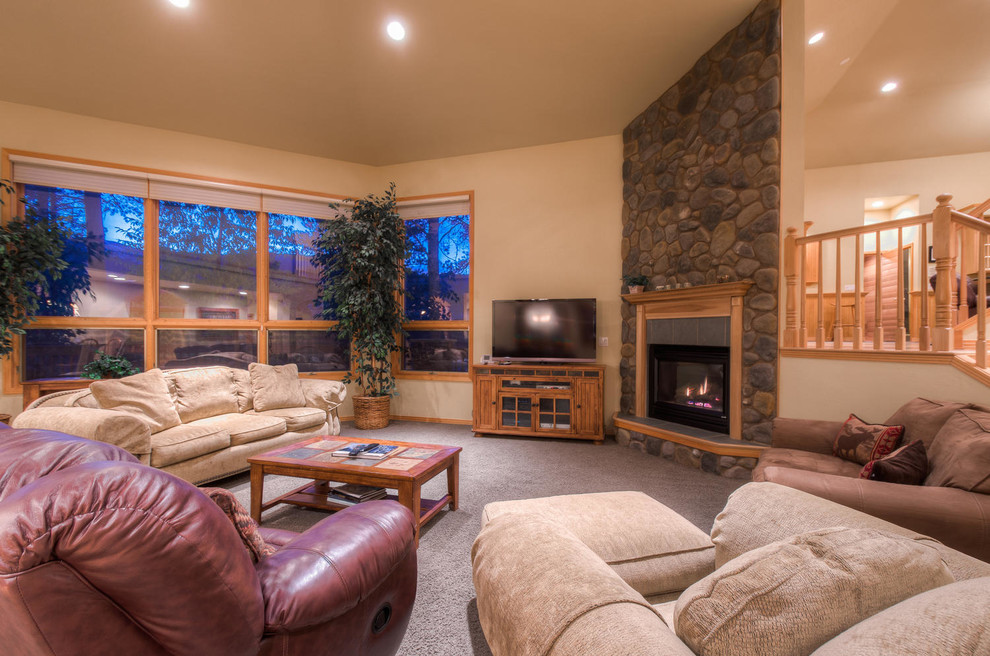 This is an example of a large traditional open concept living room in Denver with beige walls, carpet, a standard fireplace, a stone fireplace surround and a freestanding tv.