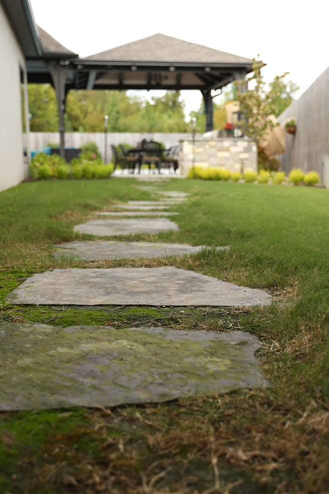 Design ideas for a mid-sized transitional partial sun backyard stone formal garden.
