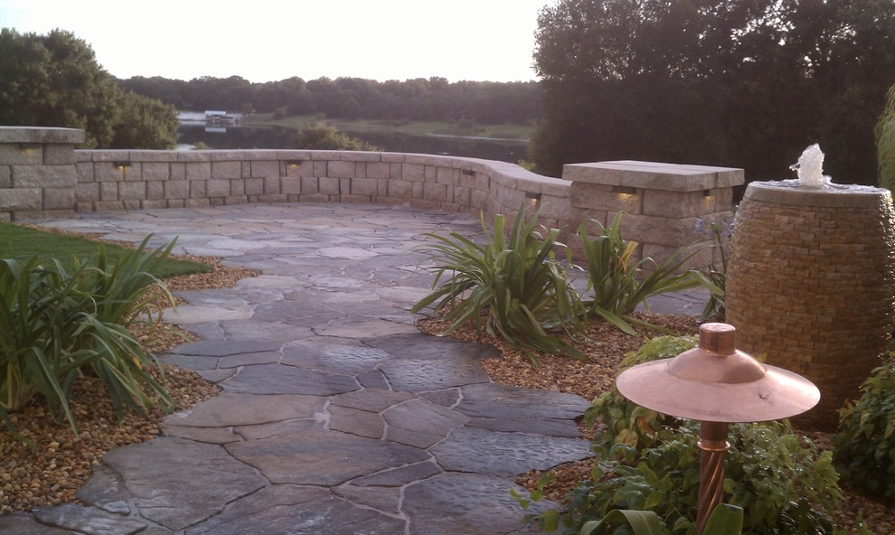 Photo of a mid-sized traditional backyard partial sun formal garden in Orlando with a water feature and natural stone pavers.