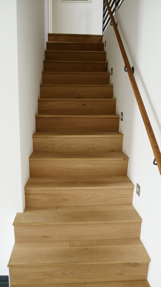 Mid-sized contemporary painted wood straight staircase in Dusseldorf with painted wood risers and wood railing.