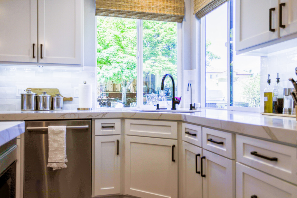 Foto på ett funkis beige kök och matrum, med en undermonterad diskho, bänkskiva i kvarts, vitt stänkskydd, stänkskydd i keramik, rostfria vitvaror och en köksö