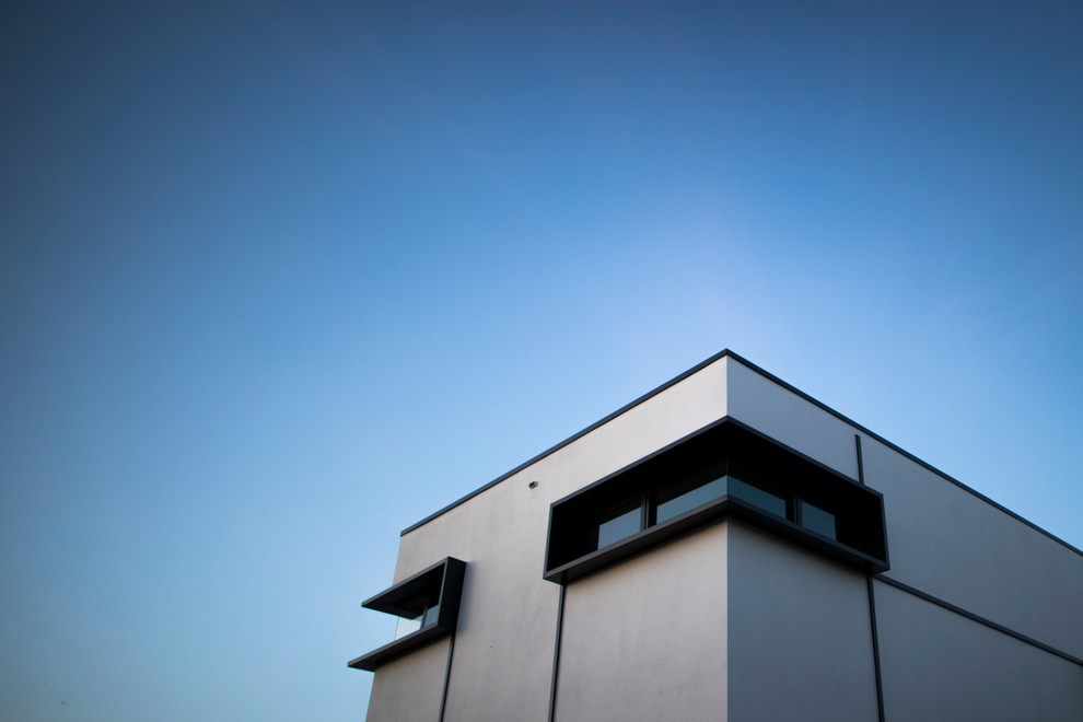 Photo of a large contemporary two-storey white exterior in Melbourne with concrete fiberboard siding and a flat roof.