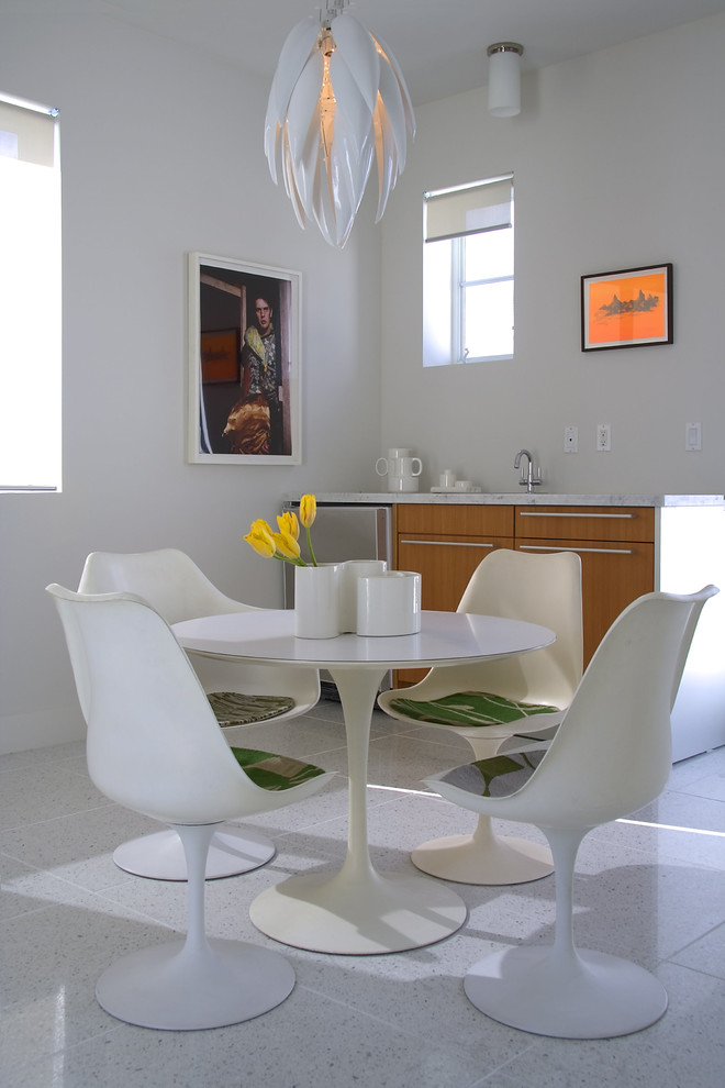 This is an example of a modern dining room in Miami with white walls.