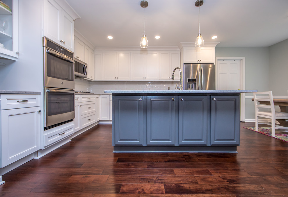 Inspiration for a mid-sized transitional l-shaped brown floor eat-in kitchen remodel in Atlanta with an undermount sink, white cabinets, quartzite countertops, white backsplash, subway tile backsplash, stainless steel appliances, an island and gray countertops