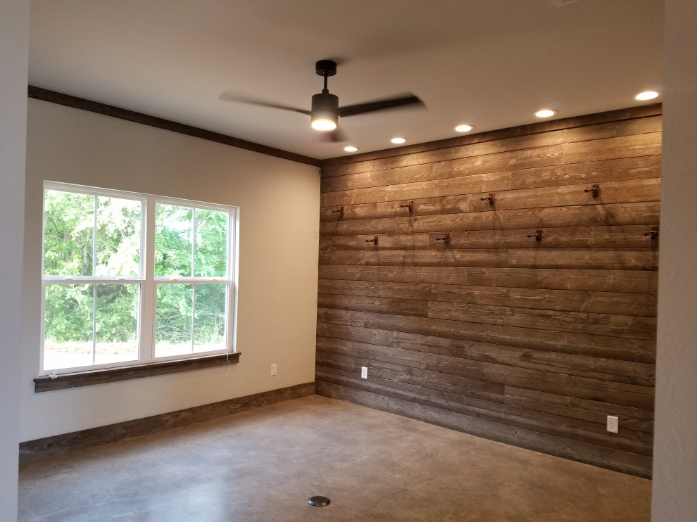 Photo of a country open concept family room in Dallas with a music area, grey walls, concrete floors, grey floor and wood walls.