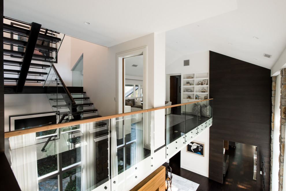 Large midcentury wood u-shaped staircase in Atlanta with glass risers and glass railing.