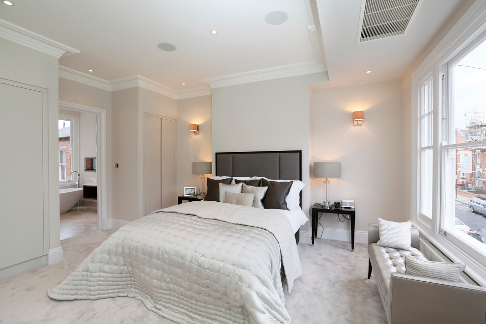 This is an example of a contemporary master bedroom in London with grey walls, carpet and grey floor.