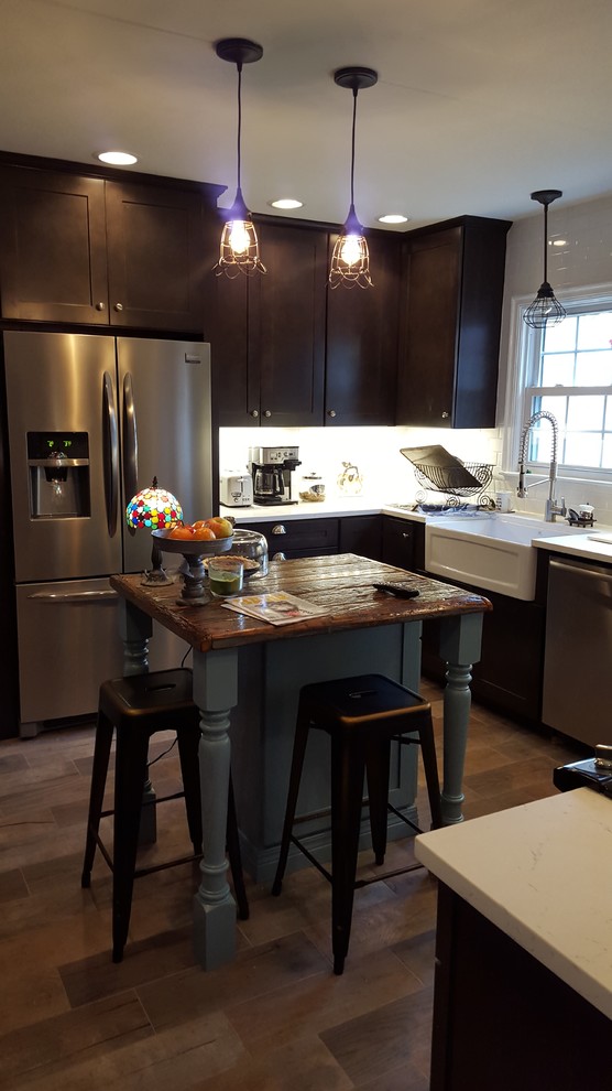 Eat-in kitchen - mid-sized rustic u-shaped porcelain tile eat-in kitchen idea in Indianapolis with a farmhouse sink, shaker cabinets, dark wood cabinets, wood countertops, white backsplash, ceramic backsplash, stainless steel appliances and an island