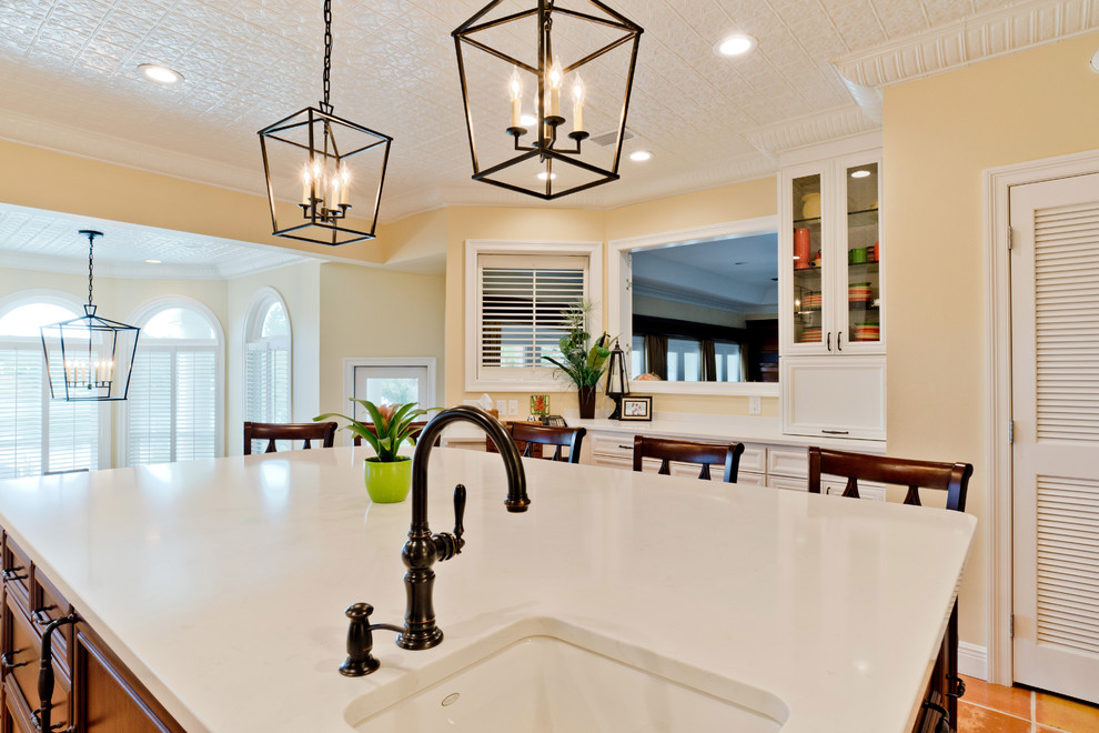 Inspiration for a large transitional u-shaped terra-cotta tile and orange floor eat-in kitchen remodel with an undermount sink, recessed-panel cabinets, white cabinets, quartz countertops, white backsplash, subway tile backsplash, stainless steel appliances and an island