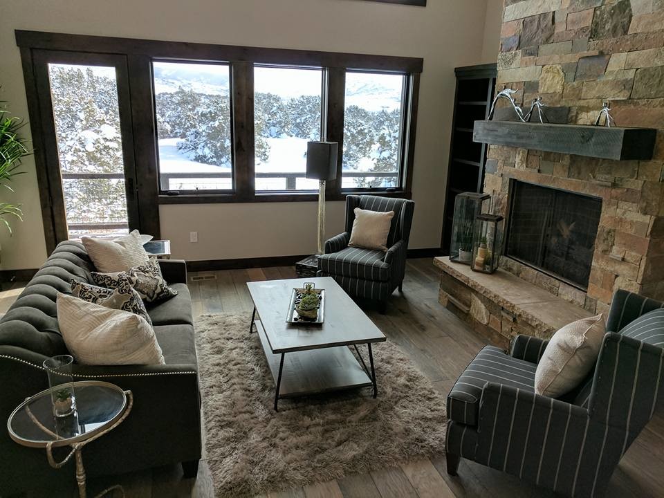 Inspiration for a mid-sized contemporary enclosed family room in Salt Lake City with beige walls, light hardwood floors, a standard fireplace, a stone fireplace surround, no tv and beige floor.