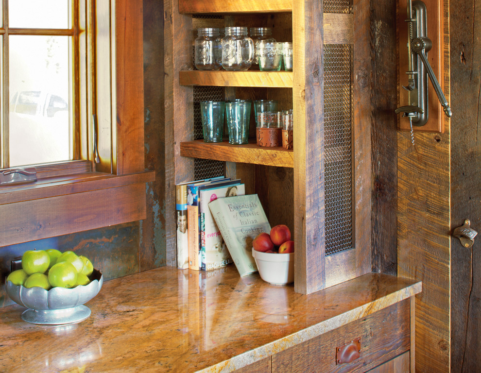 Example of a mountain style u-shaped eat-in kitchen design in Denver with a farmhouse sink, flat-panel cabinets, distressed cabinets, granite countertops and paneled appliances