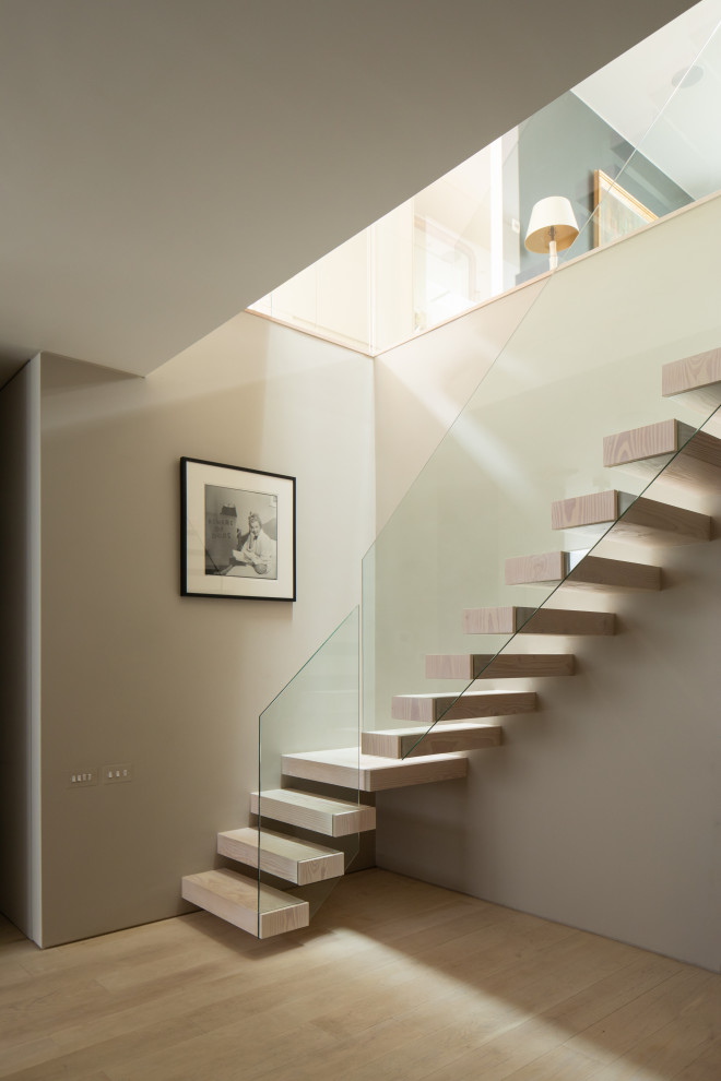 Идея дизайна: лестница на больцах в современном стиле с деревянными ступенями и стеклянными перилами